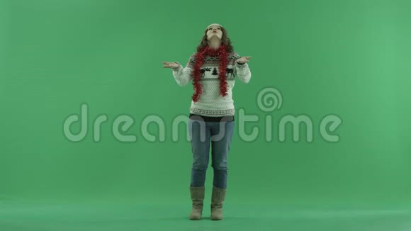漂亮的年轻女子戴着圣诞帽享受降雪背景上的彩色钥匙视频的预览图