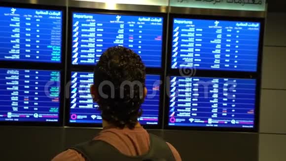 旅客看机场候机楼的时刻表国际航班商务旅客视频的预览图
