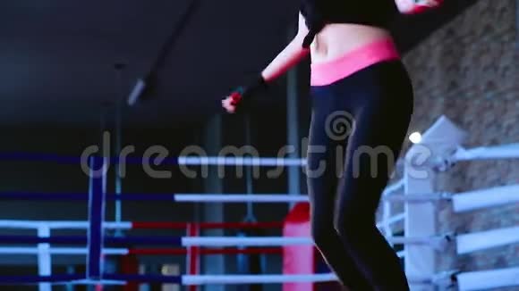 穿深色运动服跳绳健身房训练的年轻女子身材苗条视频的预览图