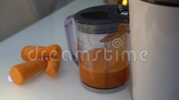 榨汁机站在桌子上把新鲜果汁挤到一个计量罐里视频的预览图