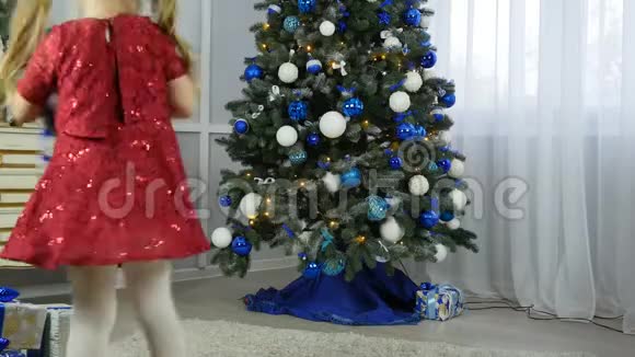 小女孩把礼物放在圣诞树下视频的预览图