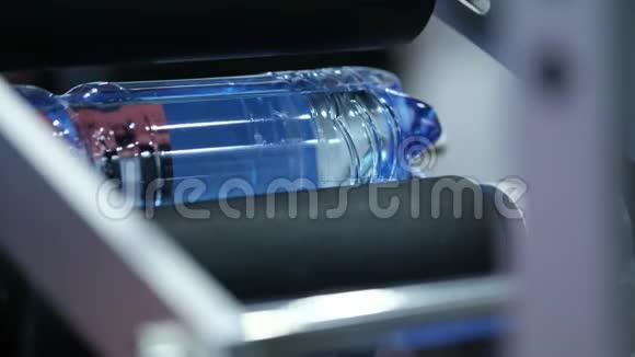 水生产线上的标签机乳制品厂的水产品标签关闭包装水瓶视频的预览图
