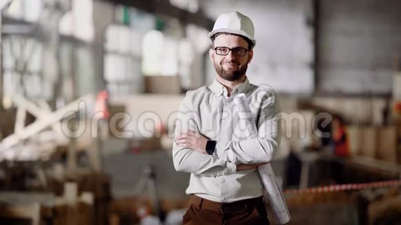 一位戴着头盔的成年建筑师站在目前的建筑工地上手里拿着一个现代化的项目视频的预览图