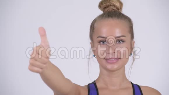 年轻的金发美女竖起大拇指的脸视频的预览图