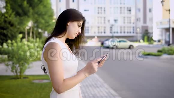 年轻迷人的女人正站在路边看夏天自拍的照片视频的预览图