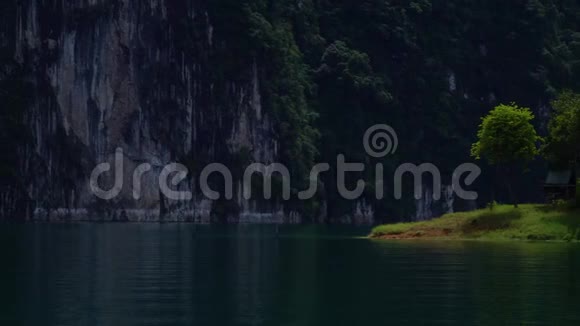 湖中一个岛上的一个小童话房子背景上的岩石视频的预览图