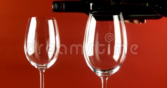 葡萄酒倒入红色背景4k的玻璃杯中视频的预览图
