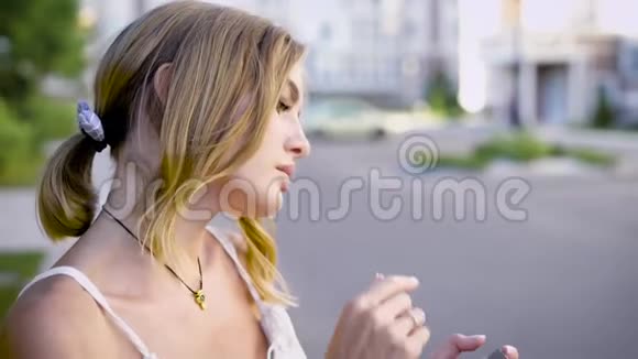 年轻迷人的女人正站在路边看夏天自拍的照片视频的预览图