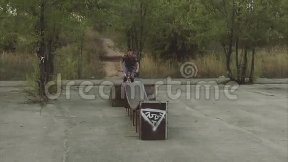 一个年轻人在夏季公园的坡道上跳起来视频的预览图