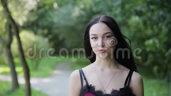 美丽的女孩正在一个美丽的公园里的摄像机上说话视频的预览图