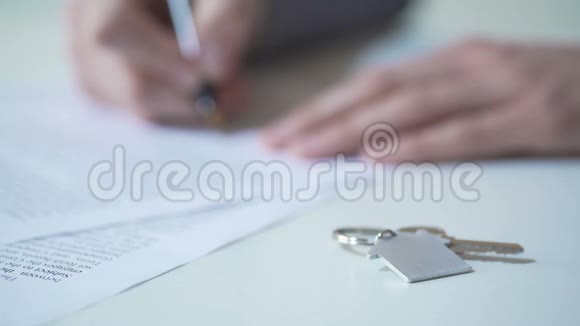签署房地产买卖协议的人桌上公寓钥匙视频的预览图