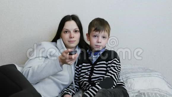 在沙发上看电视妈妈和儿子一起看电视微笑视频的预览图