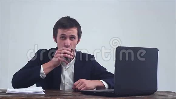 商人喝咖啡看着相机在笔记本电脑上工作视频的预览图
