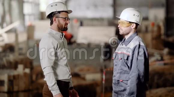 戴着防护头盔的建筑工人向商人展示了近期的工作范围工人们握手视频的预览图