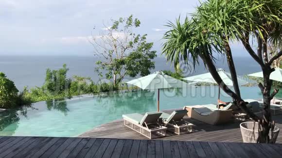 印度尼西亚巴厘岛豪华度假胜地的无限游泳池和棕榈树视频的预览图