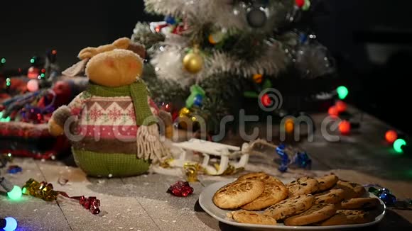 木制棕色桌子上面装饰着圣诞用品和花环男人手从盘子里拿饼干视频的预览图