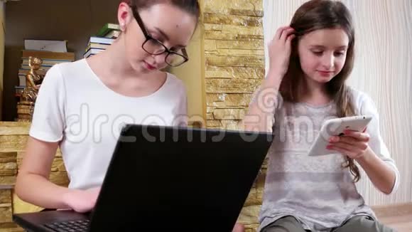 女学生在笔记本电脑上打作业姐妹通过网络搜索信息家人视频的预览图