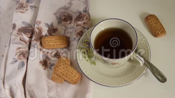 女性手蘸饼干在杯温茶中视频的预览图
