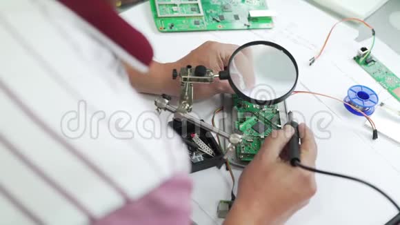 工程师在放大镜下焊一个芯片组视频的预览图