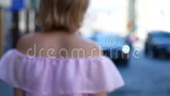 一个快乐的女孩沿着城市的街道跑一个年轻的女人在城市的小溪里旋转视频的预览图