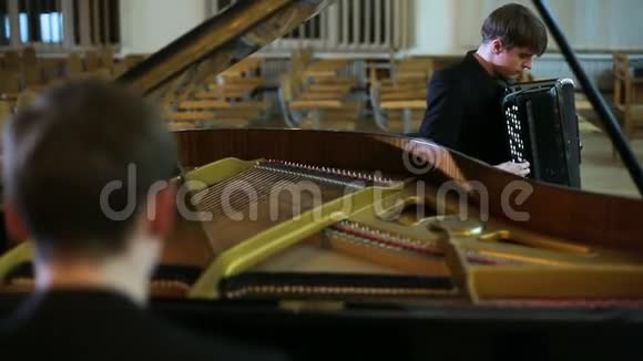 钢琴演奏家和手风琴演奏家在空房演奏音乐视频的预览图