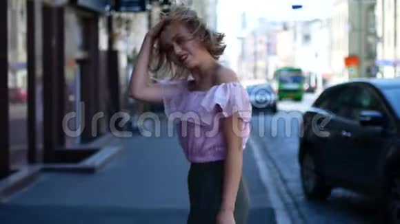 一个快乐的女孩沿着城市的街道跑一个年轻的女人在城市的小溪里旋转视频的预览图