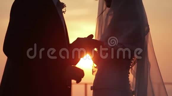 婚礼上新郎和新娘手牵着太阳从海面升起的背景视频的预览图