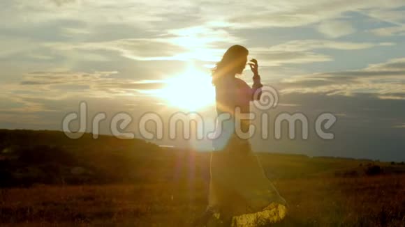 日落时分女人的剪影随着夕阳起舞视频的预览图