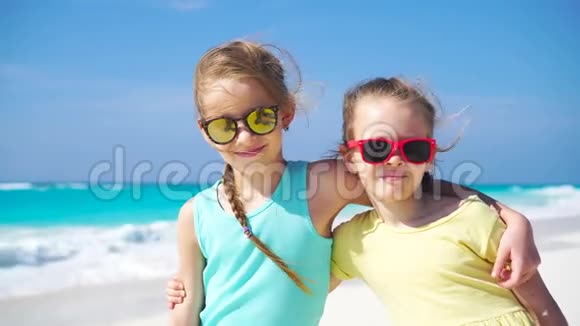 两个小女孩一起在加勒比海海滩度假两个孩子户外画像视频的预览图