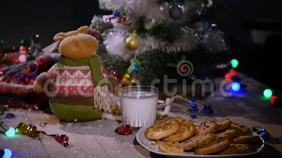 木制棕色桌子上面装饰着圣诞用品和花环男人手从盘子里拿饼干视频的预览图