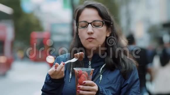 年轻女子在伦敦街头吃新鲜草莓视频的预览图