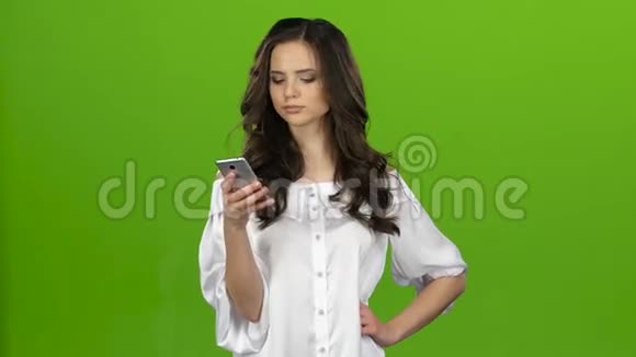 女孩看着手机选择她需要的信息绿色屏幕视频的预览图