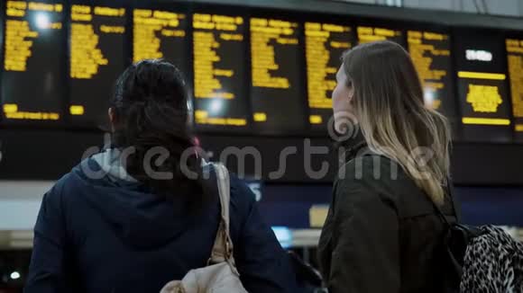 两名年轻女子在火车站检查发车时间视频的预览图