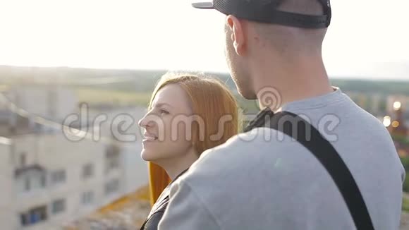幸福的年轻漂亮的时髦夫妇在房子的屋顶上拥抱在一起视频的预览图