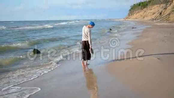 微笑的白种人女人穿着蓝色头巾在海滩上散步享受生活假期概念视频的预览图