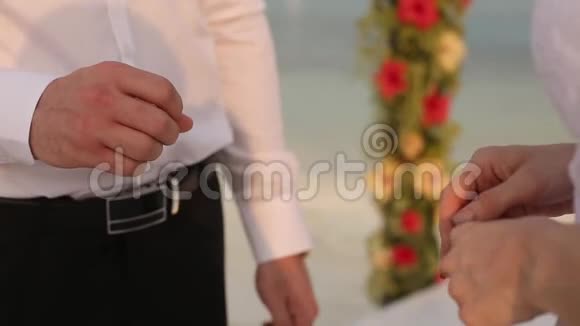 热带岛的浪漫婚礼和蜜月女人把结婚戒指戴在沙滩上男人的手上新娘和视频的预览图