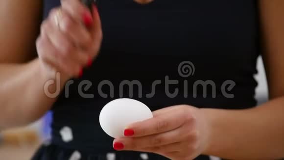 女厨师用刀子打碎鸡蛋动作缓慢女的手拿刀打鸡蛋特写视频的预览图