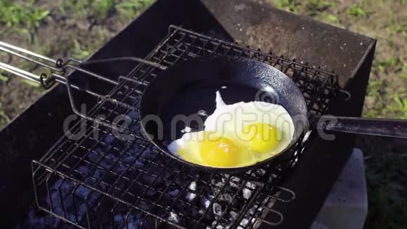 在后院的煎锅上煮鸡蛋视频的预览图