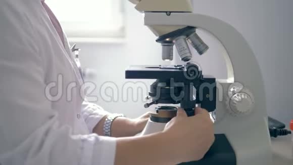 一个用显微镜工作的女人特写视频的预览图