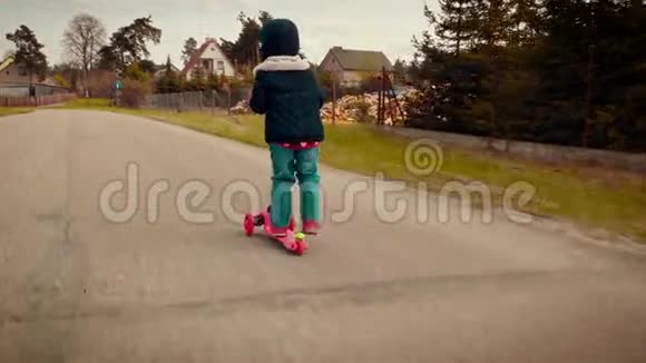 穿夹克的小女孩骑着摩托车在乡间小路上视频的预览图
