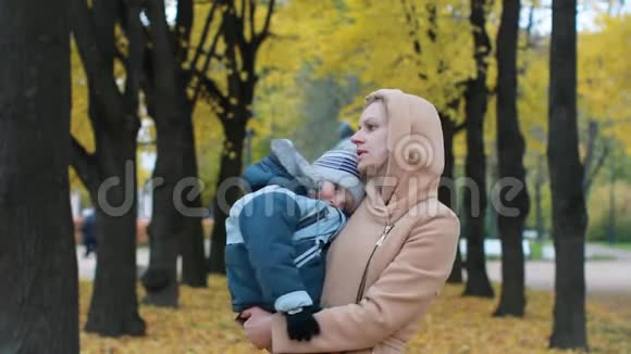 妈妈和儿子正在一个美丽的秋天公园里休息视频的预览图