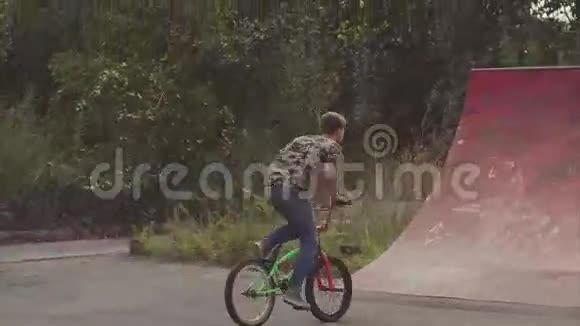 年轻人在公园里骑一辆BMX自行车他表演了一个叫努亨德的把戏视频的预览图