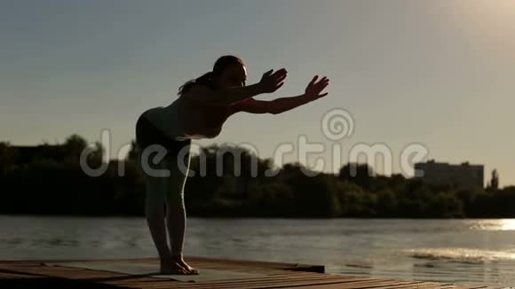 剪影苗条运动女孩做瑜伽在日落视频的预览图