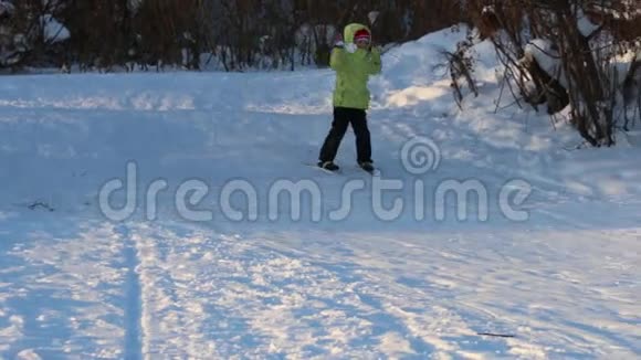 穿着黄色衣服的女滑雪者从山上滑下来在冬日跌倒视频的预览图
