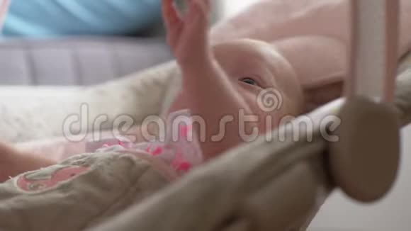 冷静的女婴在家里的弹性座椅上视频的预览图