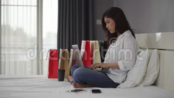 使用笔记本电脑在床上进行网上购物的女性压力很大而且信用卡被屏蔽视频的预览图