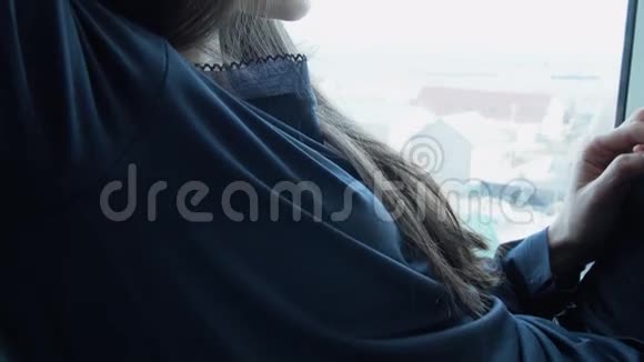 一个甜美的年轻的女人正在等待她心爱的家坐在窗户上一位美丽的年轻女子坐在窗户上视频的预览图