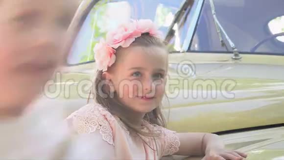 在复古车上穿着粉色小裙子的女孩视频的预览图