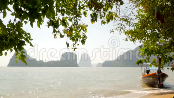 静静的海浪轻轻地在热带沙滩上的树荫下翻滚视频的预览图