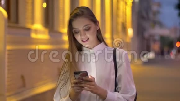 年轻有魅力的女孩在夏天的晚上在智能手机上输入信息思考概念交流概念视频的预览图